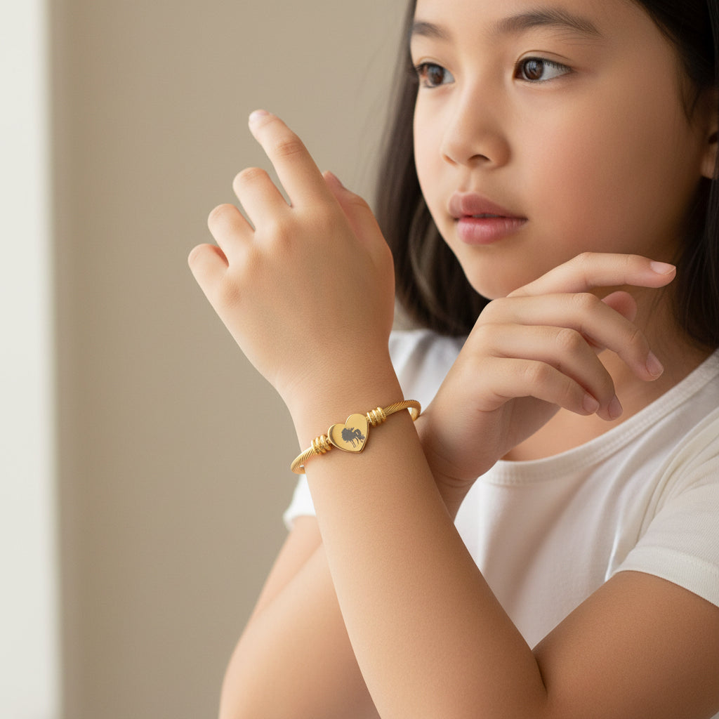 Gold bracelet with a heart-shaped tag displaying 'LOVE' on a white background