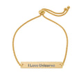 A gold adjustable chain bracelet with a horizontal bar engraved with the word 'Blessed' in a dark gray font, shown on a plain white background.