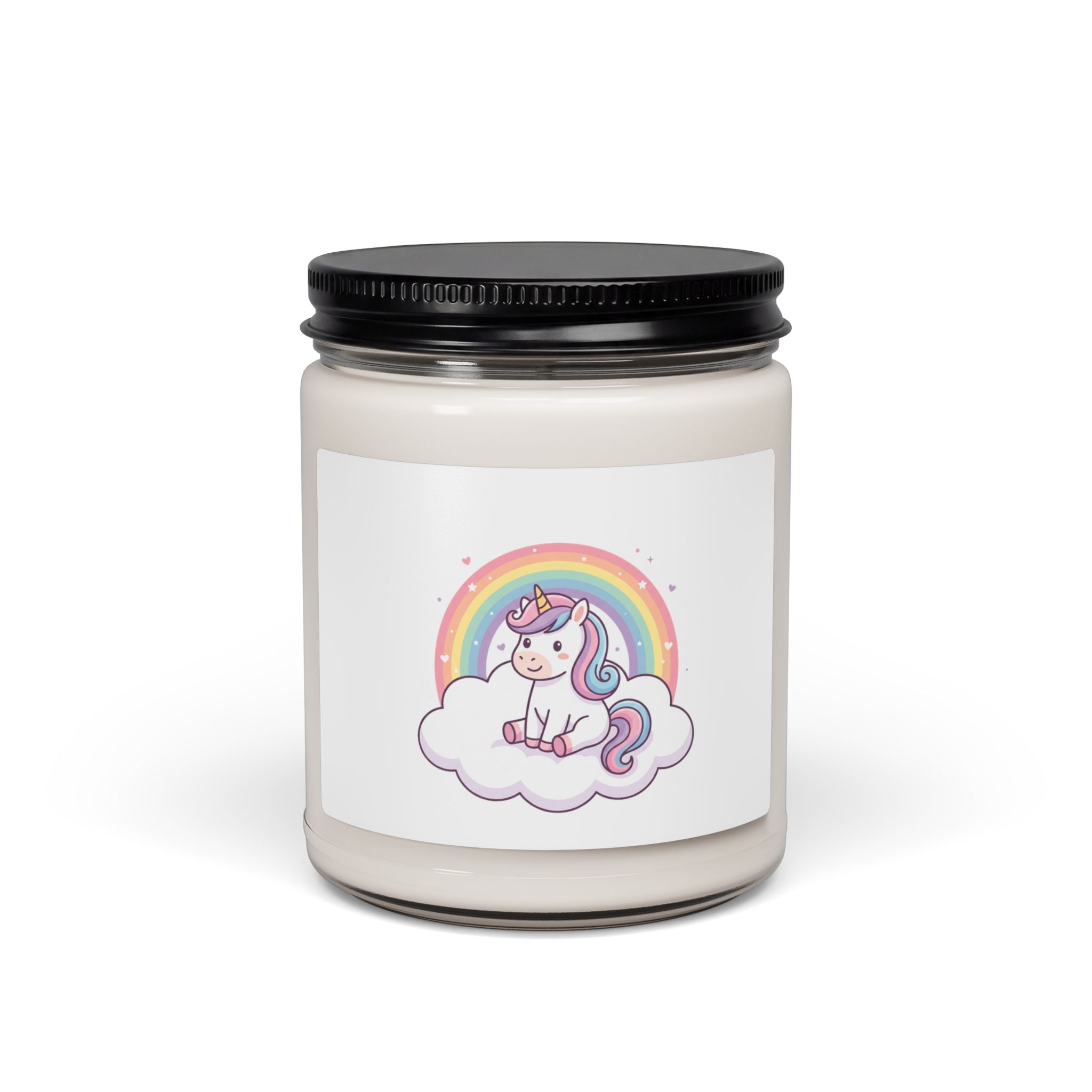 A jar candle with a black metal lid and a white label featuring a cute cartoon unicorn sitting on a cloud under a rainbow. The candle is set against a plain white background.
